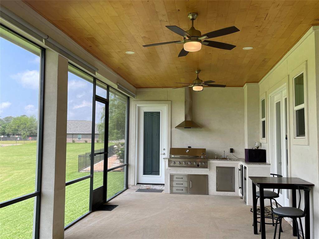 Screend Porch with Shades with an Outdoor Kitchen