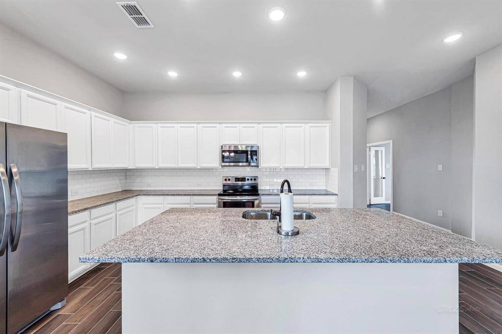 Take a look at the many white cabinets for storage and the endless countertop space available in the kitchen.