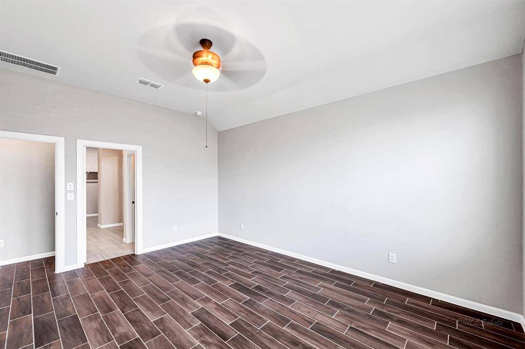 Here's another view of this amazing primary retreat, showcasing the absence of carpet and the attached bathroom.