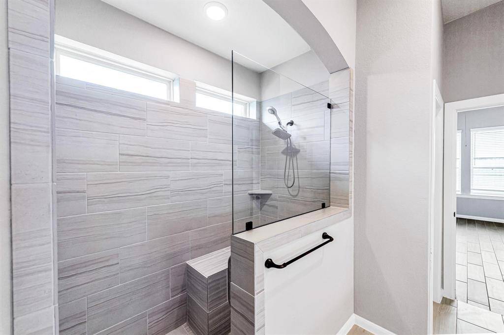 Here's a view of the incredible upgraded walk-in shower, featuring bench seating and pocket windows for abundant natural lighting.