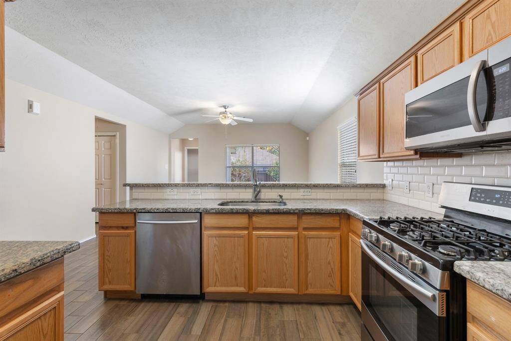 The appealing kitchen features stainless steel appliances, granite countertops and breakfast bar.