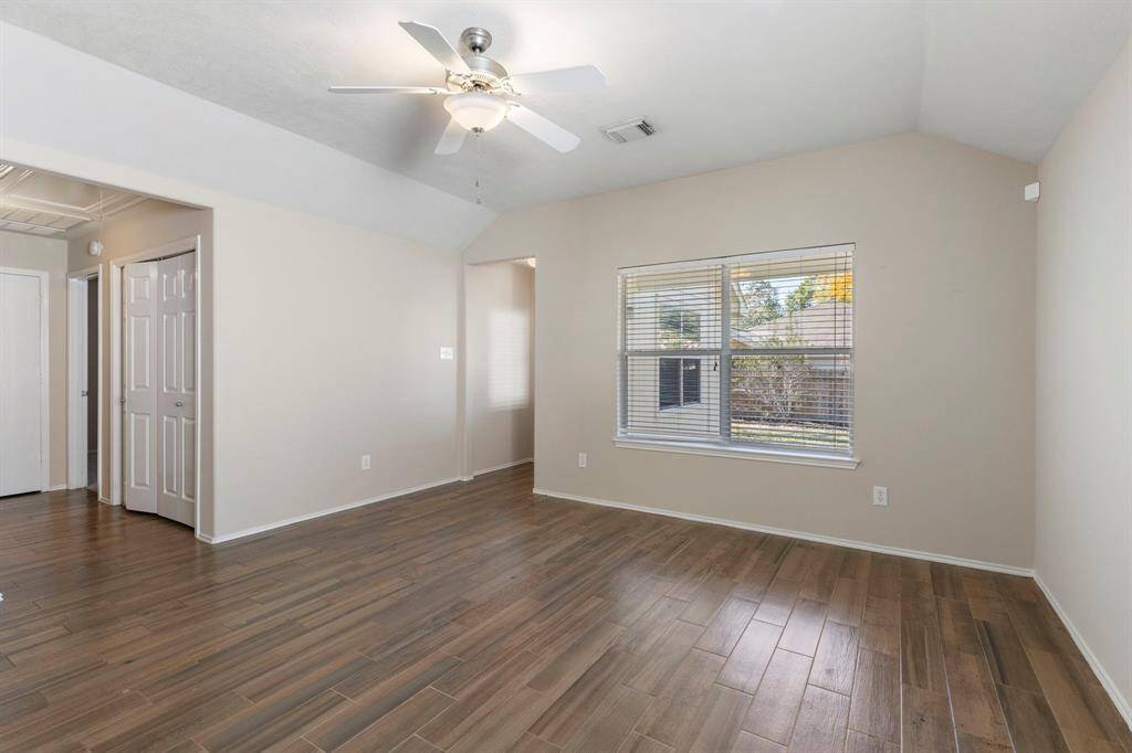 The generously sized den features high ceilings, tile floors, neutral paint and fan.