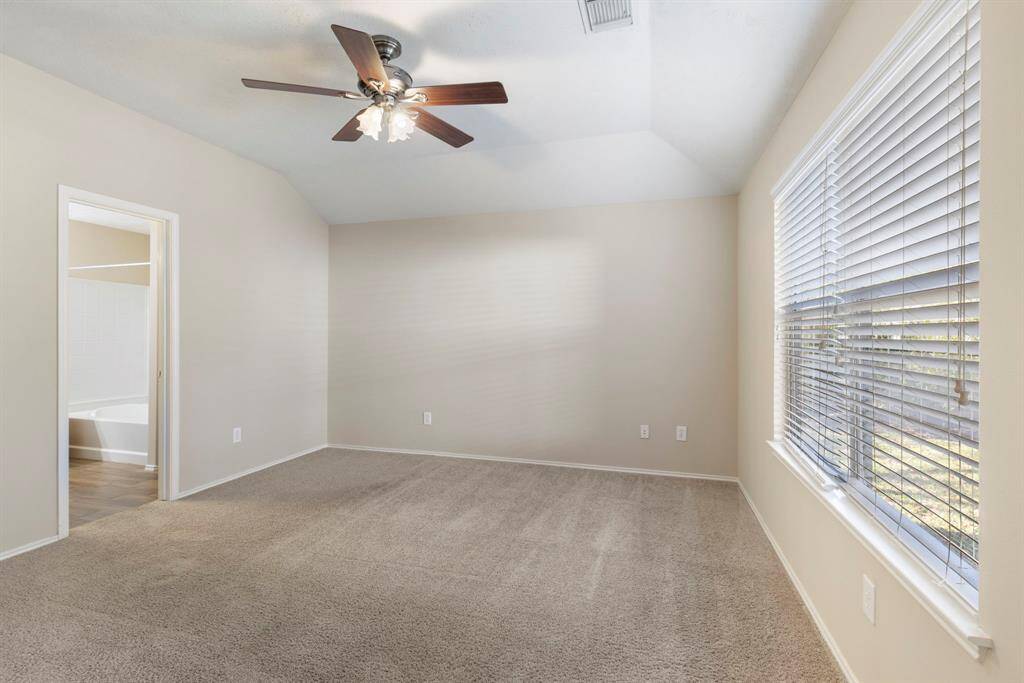 The primary bedroom has a large window allowing plenty of natural light.