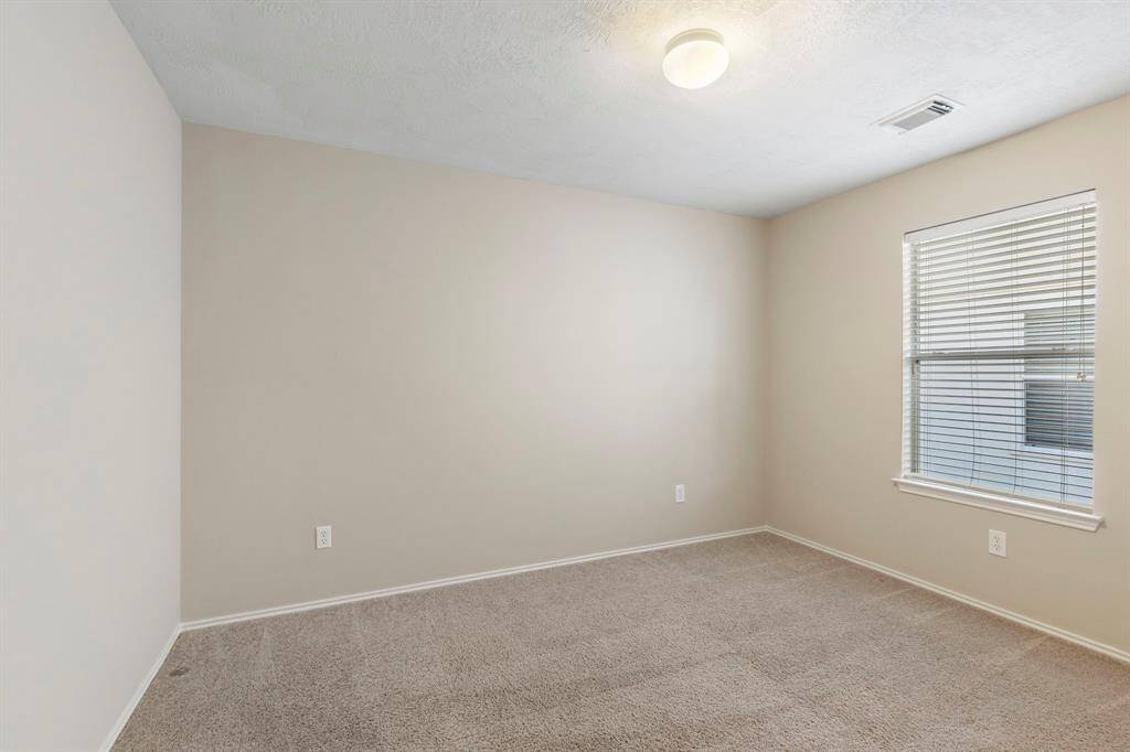 Secondary bedroom #1 has carpet, a walk in closet and neutral paint.