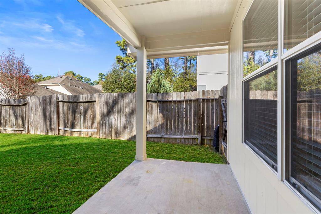 The fully fenced back yard has a covered patio area.