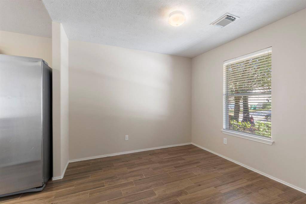 The quaint dining room is located just off the main entry and features wood-look tile flooring.