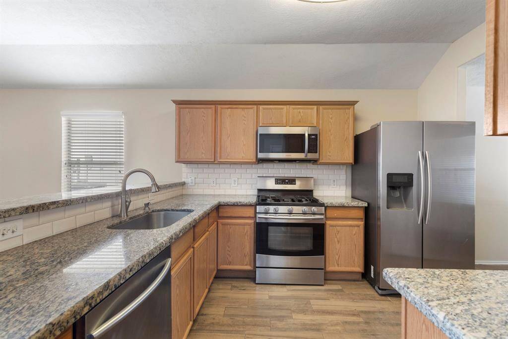 The kitchen offers subway tile backsplash, ample counter space and plenty of cabinet storage.