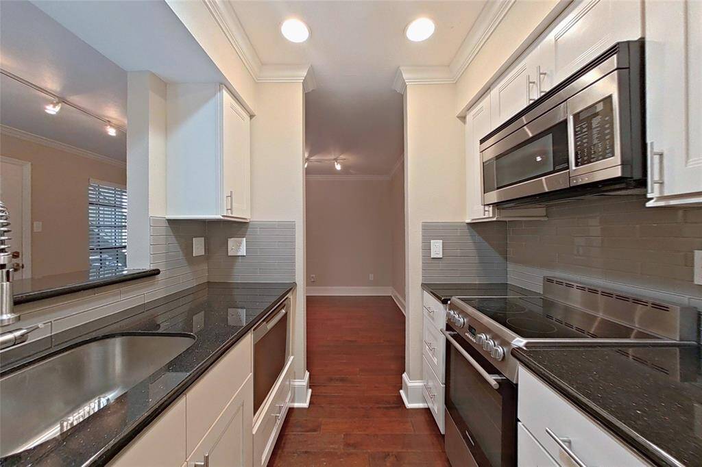 The spacious kitchen offers granite counters, pretty glass tile backsplash areas and high-end stainless steel appliances!