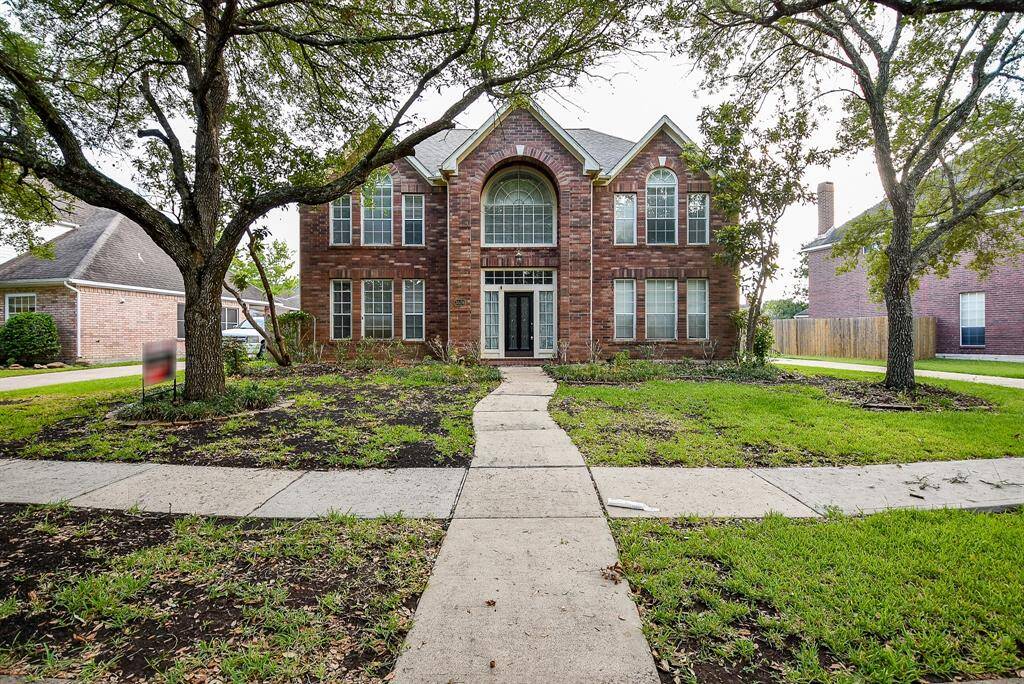 This elegant two-story brick home features a grand entrance and front facing windows for plenty of natural light.