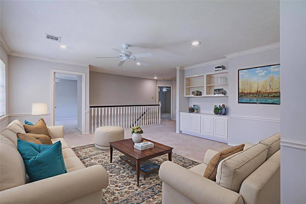 Virtually Staged. Another view of the huge flex space with built in cabinetry, crown molding and chair rail trim. Freshly painted!