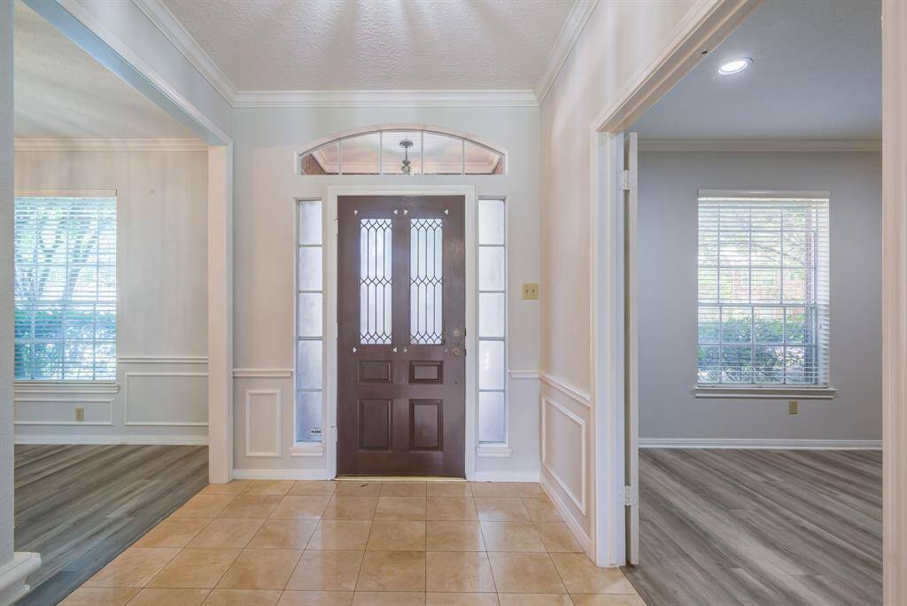 Welcome into this wide entryway with great lighting, crown molding, high ceiling and gorgeous tile floor.