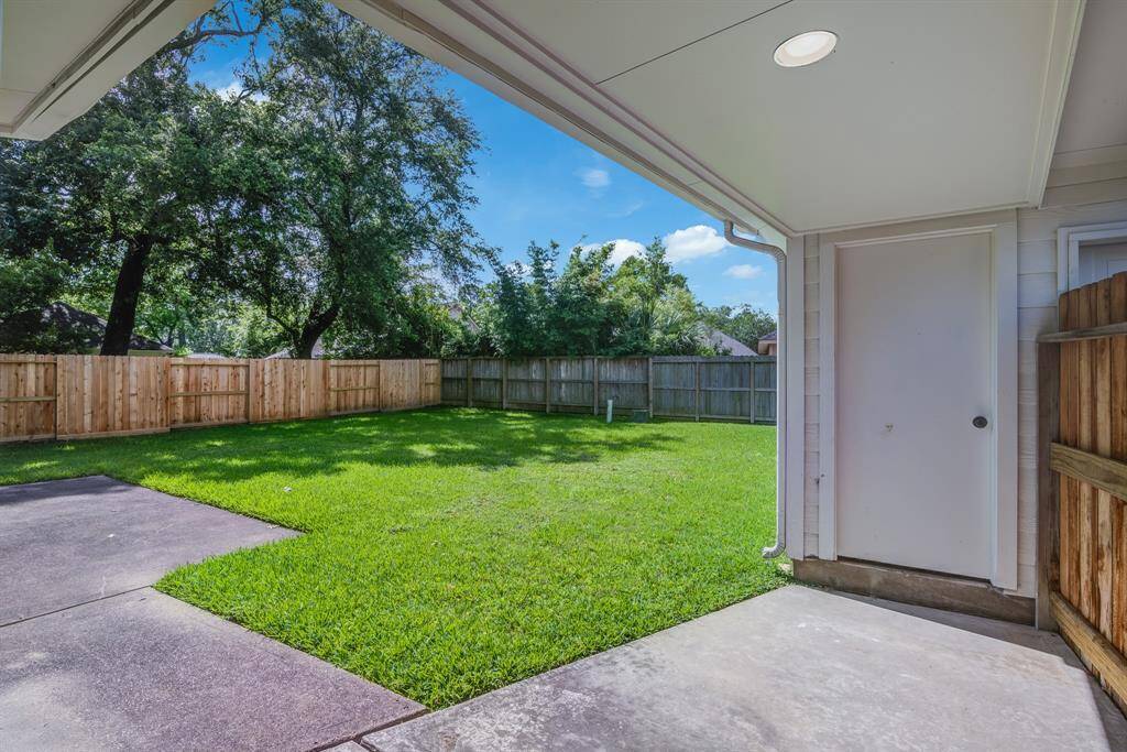 Rear yard with covered walkway to two car garage.