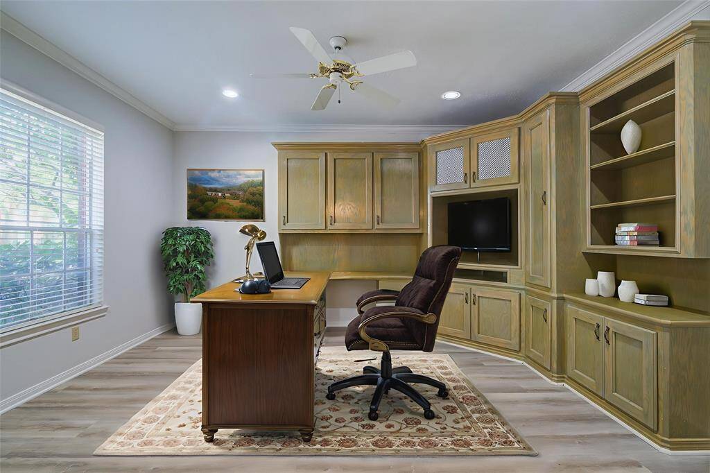 Virtually Staged. Separate office space at front of the home with large window and built in cabinetry to house supplies, printer and everything you need to work from home.