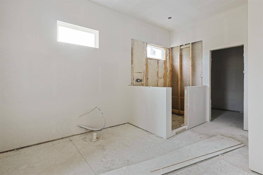 This view showcases the thoughtful layout of the primary bathroom, featuring a roomy walk-in shower and the designated space for a luxurious soaking tub. With ample space and clean lines, the design balances functionality and elegance, setting the stage for a serene personal oasis.