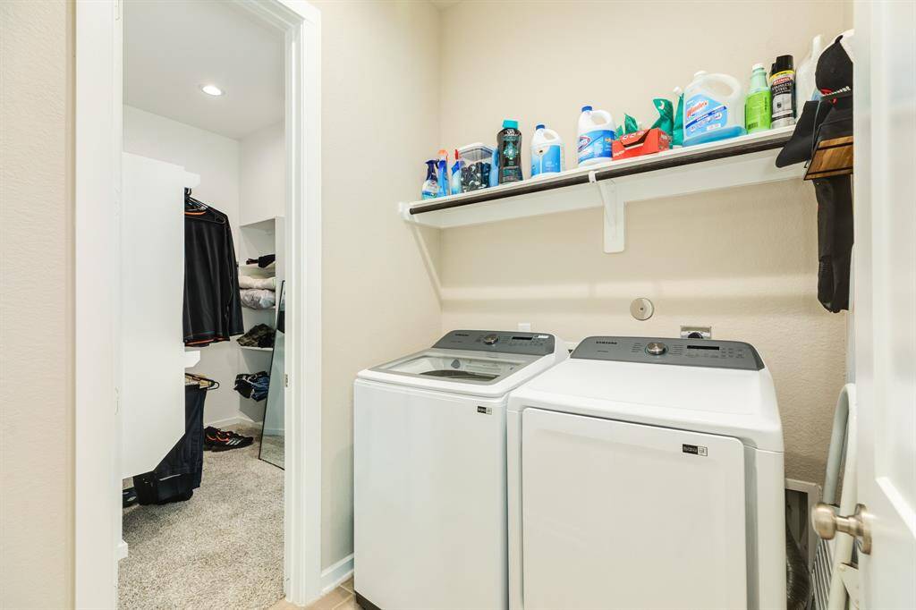 laundry room which has a door to one of the primary closets in the primary bed room