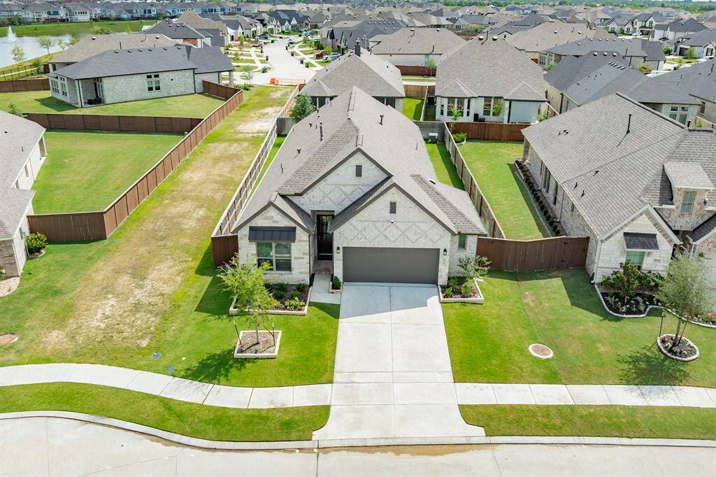 aerial view of the home shows the green space double wide driveway has a 30 year roof