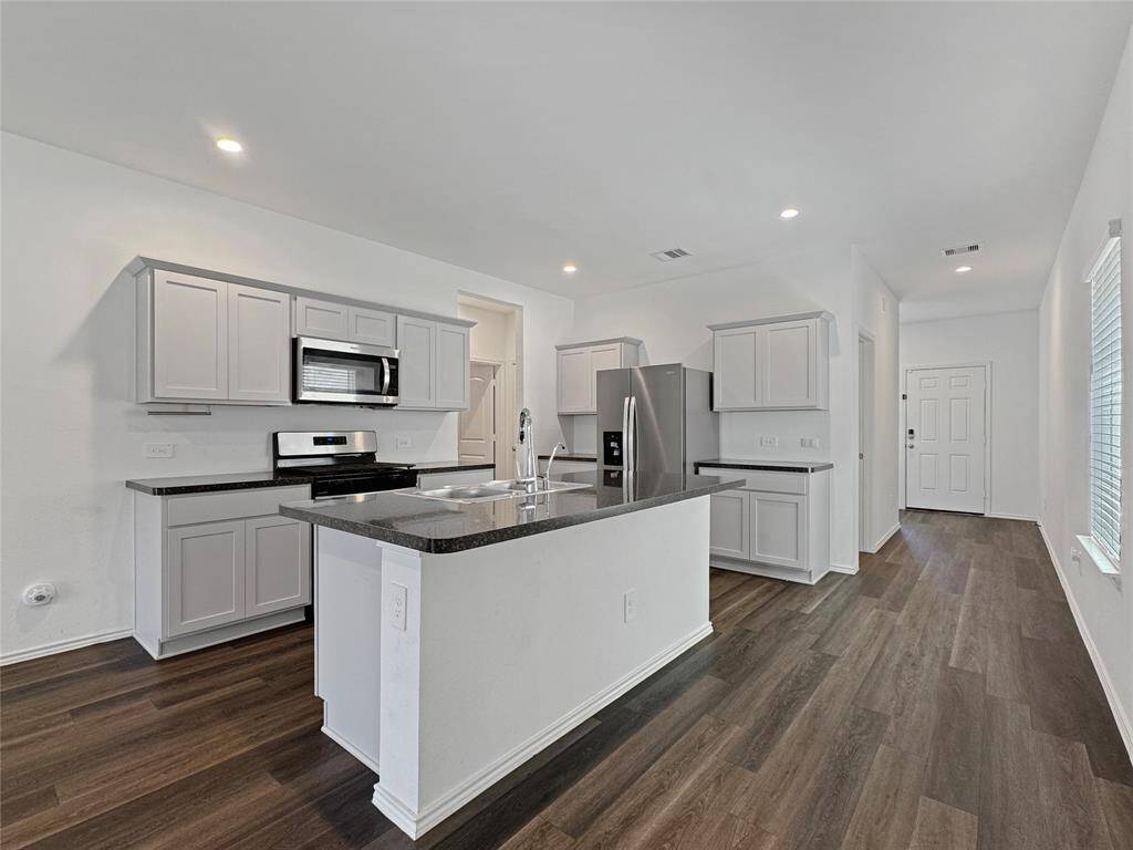 View of kitchen - entry from garage and utility room in the back corner.