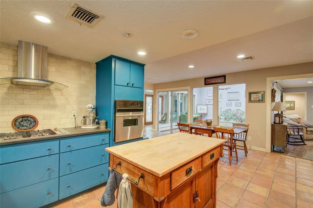 The bright breakfast area at the front of the photo opens to the kitchen and offers a seamless view into the formal dining and living rooms.