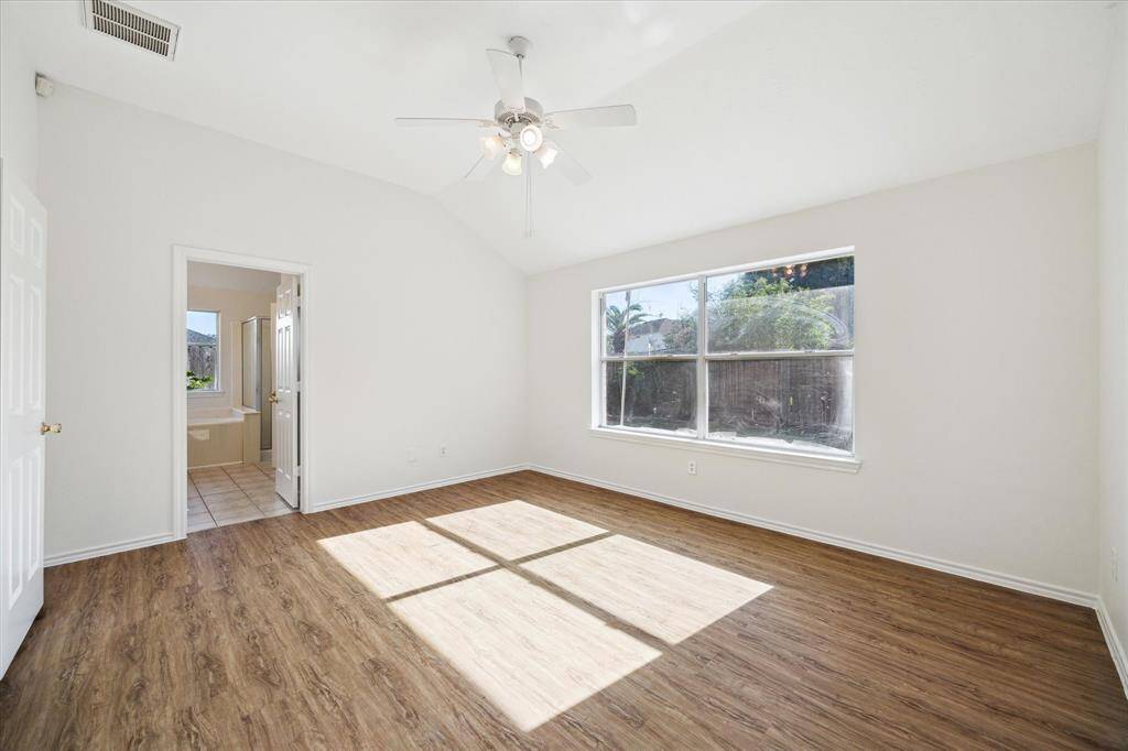 The primary suite features soaring ceilings and natural light