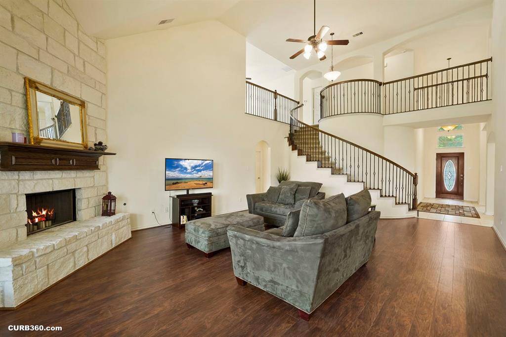 spacious living area features high ceilings, a grand staircase,