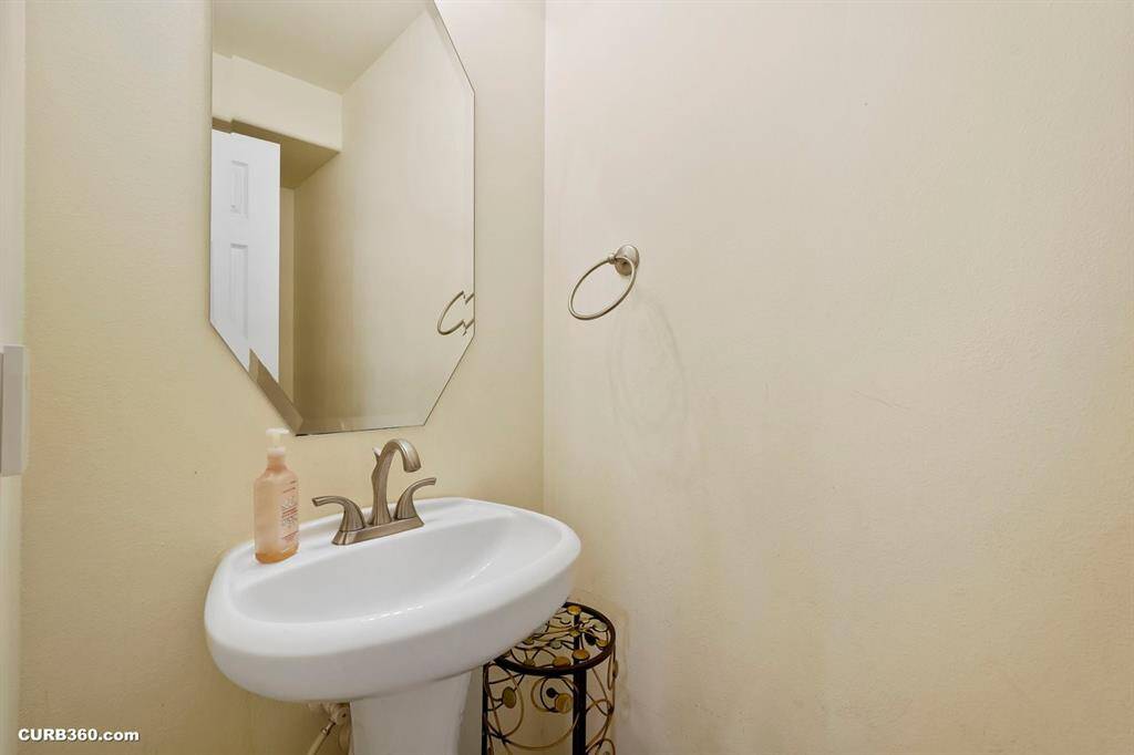 a compact half-bathroom featuring a pedestal sink