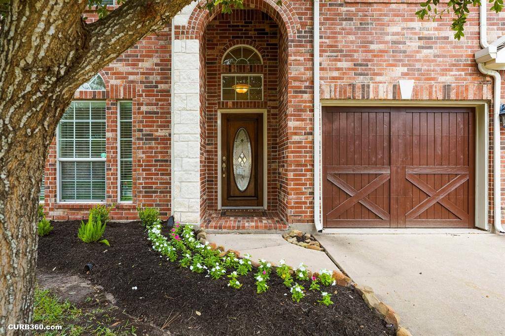 well-maintained yard includes a flower bed lined with vibrant blooms.