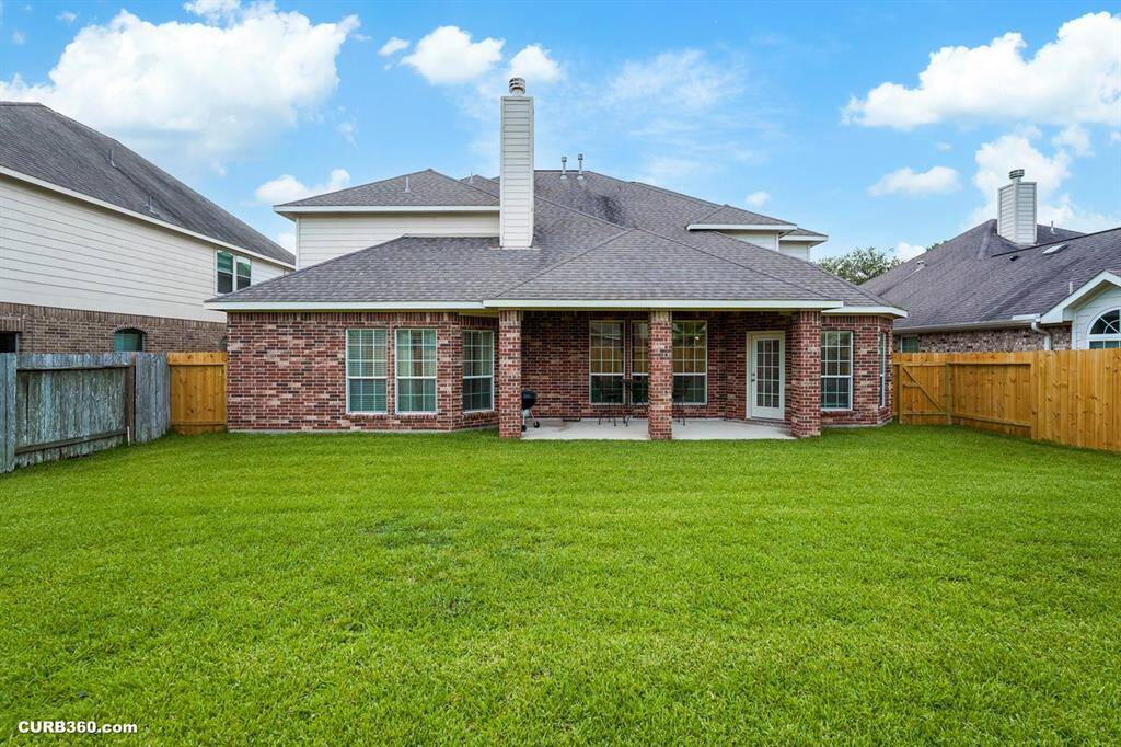 backyard enclosed by a wooden fence, offering privacy and a great space for outdoor activities.