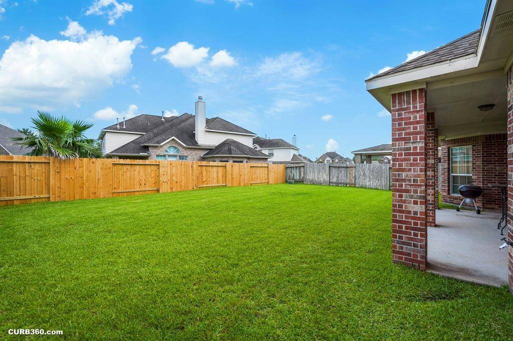 backyard with well-maintained lawn, privacy fencing, and a covered patio area