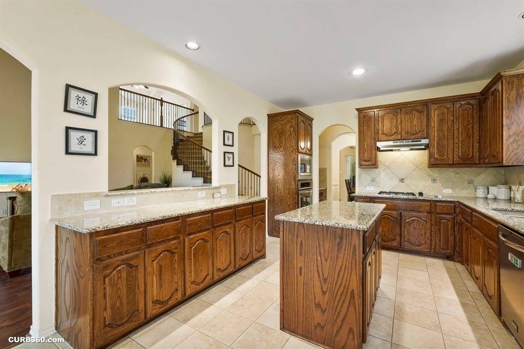 This spacious kitchen features granite countertops, and a central island.