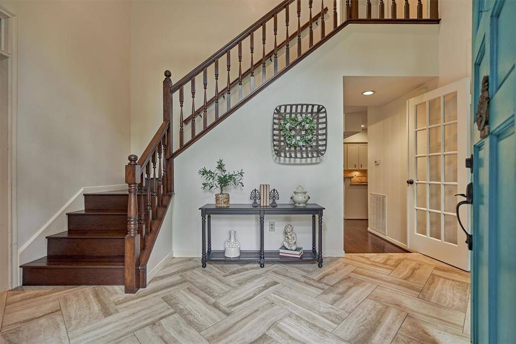 Stunning Entry with herringbone tile, wood tread stairs, two story ceiling.