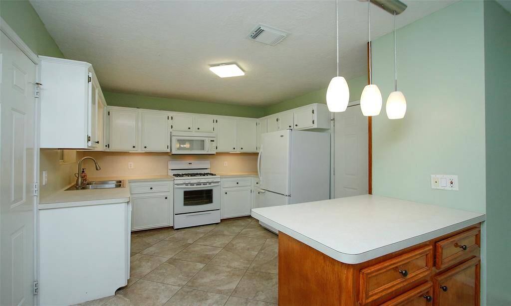Kitchen boasts plenty of cabinet storage, under cabinet lighting, and breakfast bar with pendants!