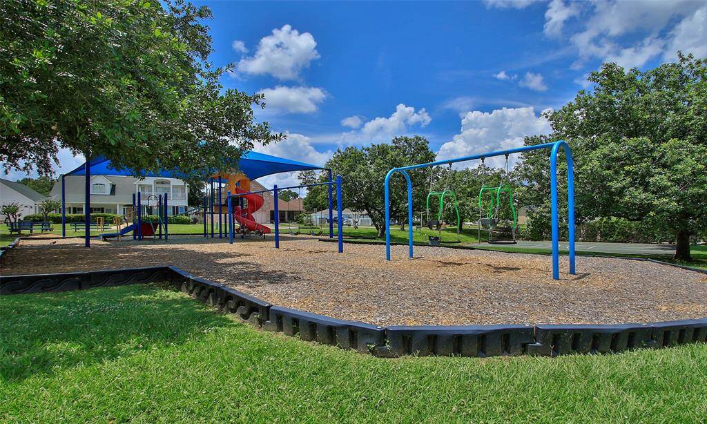 Community park with several swings and shaded play structure.