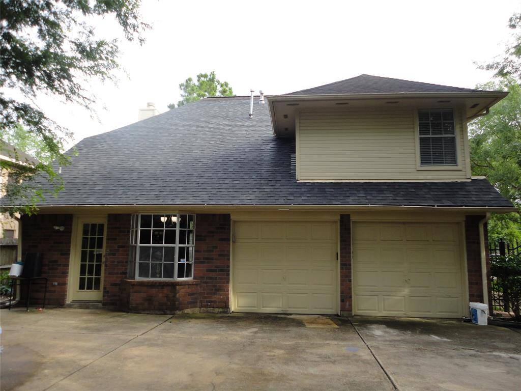 REAR VIEW OF THE HOUSE.  GARAGE  OPEN IN THE BACK.