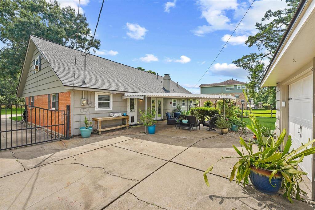 View of the home’s rear elevation featuring a spacious covered patio and lush backyard—perfect for outdoor living and entertaining.