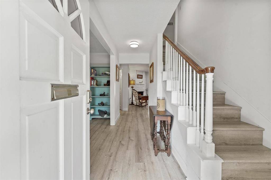 As you enter through the front door, you're welcomed by a spacious foyer and a staircase that leads to the upstairs guest suite or game room—perfect for multigenerational living or flexible entertaining space.
