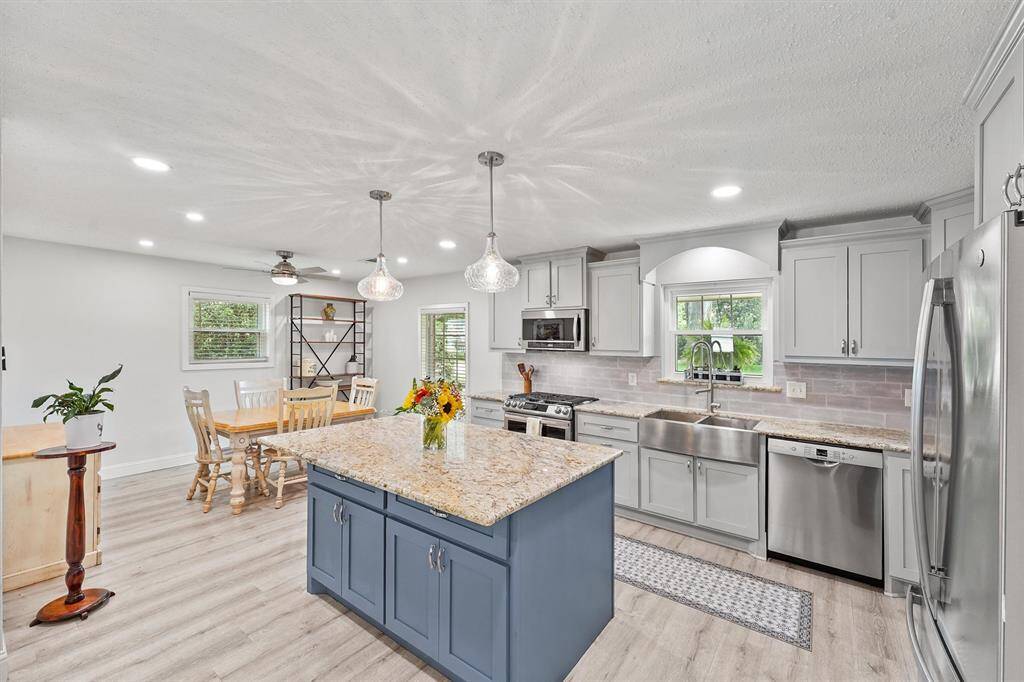 Modern kitchen equipped with stainless steel appliances, granite countertops, and ample cabinetry.