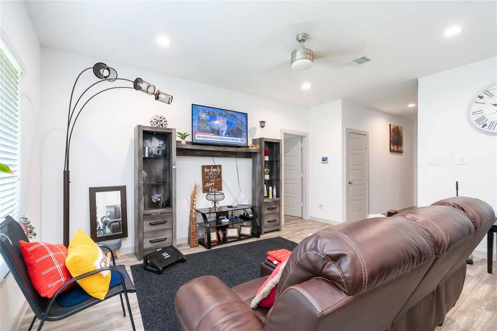 Bright and open living area with soaring ceilings, abundant natural light, and elegant wood-look flooring for a warm, contemporary feel.